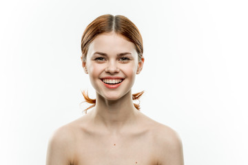 happy woman with a beautiful smile, naked shoulders, light background