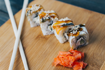 rolls of ginger and chopsticks on a cutting board