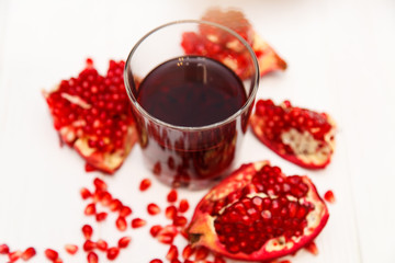 A glass of pomegranate juice and pomegranate seeds