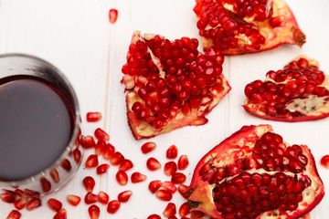 A glass of pomegranate juice and pomegranate seeds