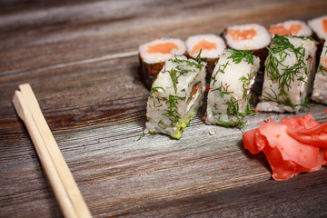 ginger, sushi and rolls on a wooden background
