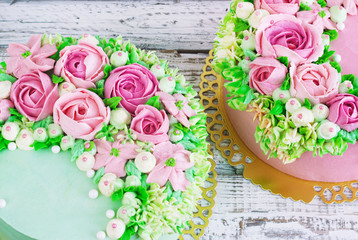 Two celebratory cake with flowers rose on a white wooden background