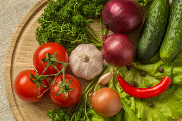 raw vegetables on a round wooden Board.