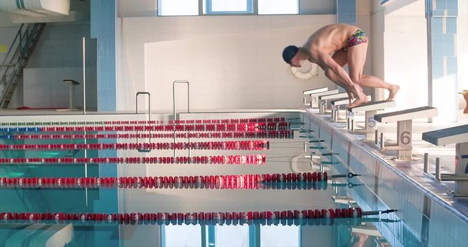 Male swimmer jumps off starting block and start swims in pool HD slow-motion video. Professional athlete training: dive and splashes water surface