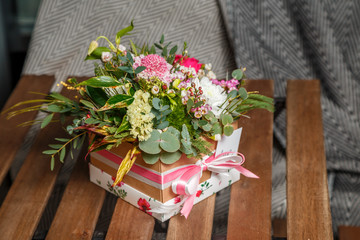 Fototapeta na wymiar букет из миниатюрных цветов в подарочной коробке с бантом 