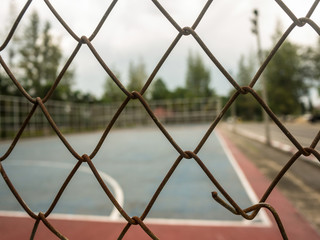 Wire fence with futsal field on background