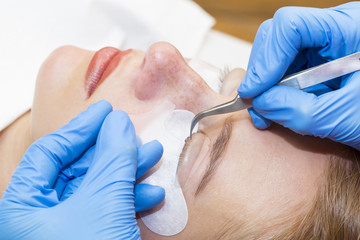 Woman on the procedure for eyelash extensions, eyelashes lamination 