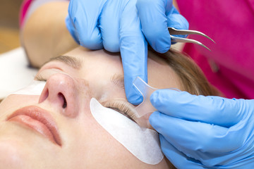 Woman on the procedure for eyelash extensions, eyelashes lamination 