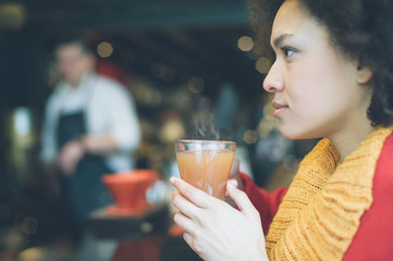 Beautiful young woman enjoying tea in a restaurant