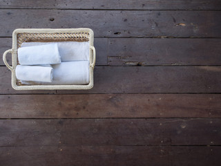 Fototapeta na wymiar Clean white towels in a basket on a wooden floor