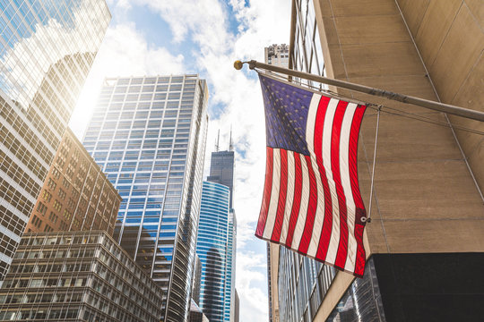 USA flag in Chicago with with skyscrapers on background