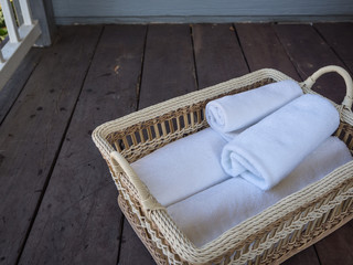 Obraz na płótnie Canvas Clean white towels in a basket on a wooden floor