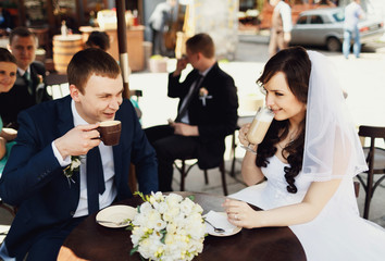 Newlyweds drinking coffee looking each other in the eye