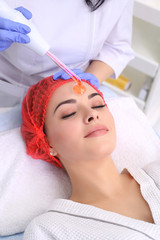 Obraz na płótnie Canvas Receiving electric darsonval facial massage procedure.