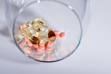 capsule and pills inside wineglass