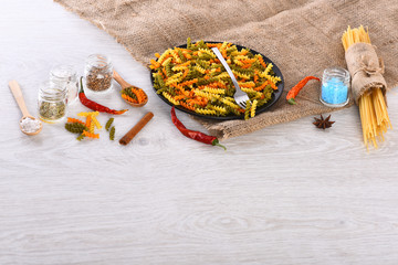 Dried colorful italian pasta with fork and spoons