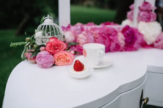 beautiful pink flowers and white cup lying on a white table