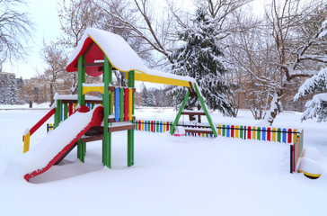 Children's playground covered with snow in winter