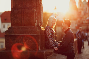 young and happy woman and man siiting outdoors at sunset