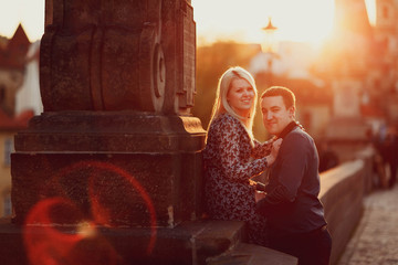 young and happy woman and man siiting outdoors at sunset