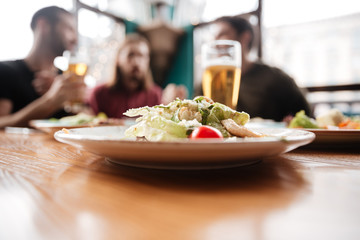 Friends sitting in cafe. Focus on food.