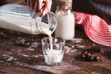 Pouring new milk into glass closeup. Fresh rustic beverage, drinking organic milk. Healthy...