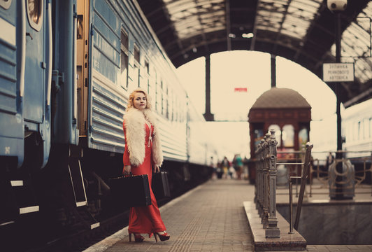 the girl with suitcases goes out the train.