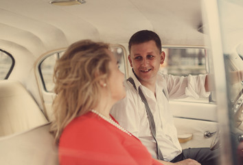 The lovely couple in love look at each other in car