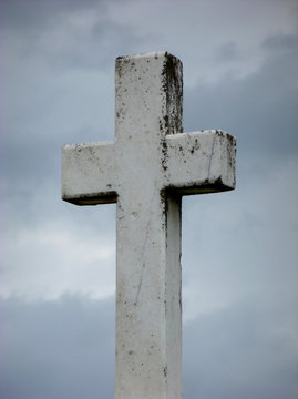 Picture of an old Christian cross standing in front of cloudy sky