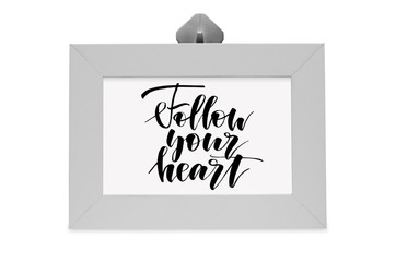 Follow your heart. Handwritten text. White photo frame. Modern calligraphy.