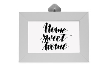 Home sweet home. Handwritten text. White photo frame. Modern calligraphy.