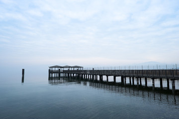 Fototapeta na wymiar molo sul lago in una giornata nuvolosa