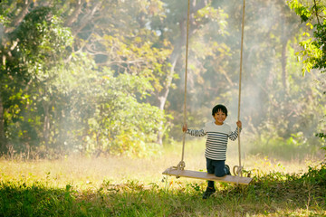 Child boy on swinging in the park