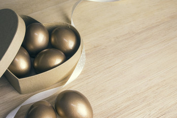 gold eggs in heart box paper with ribbon