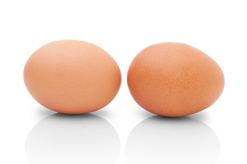 Two brown chicken eggs for cooking. Profile shot. Isolated on white background with shadow reflection. Two brown chicken eggs for baking, on white background. Two eggs to kitchen. Two eggs