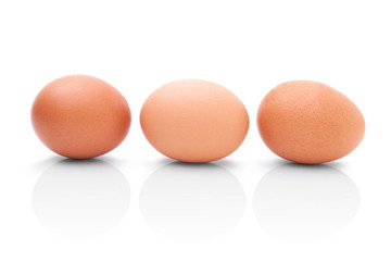 Three brown chicken eggs for cooking. Profile shot. Isolated on white background with shadow reflection. Three brown chicken eggs for baking, on white background. Three eggs to kitchen. Three eggs