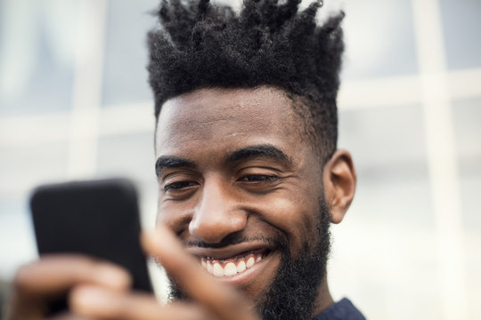 Close-up of a happy man using a smart phone