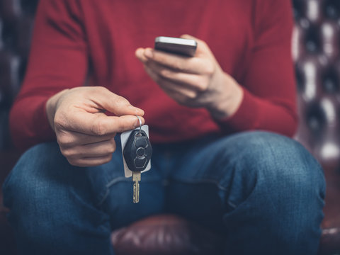 Man with car keys and smartphone