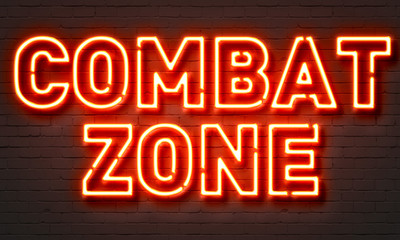 Combat zone neon sign on brick wall background.