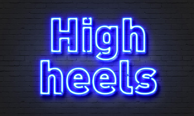High heels neon sign on brick wall background.