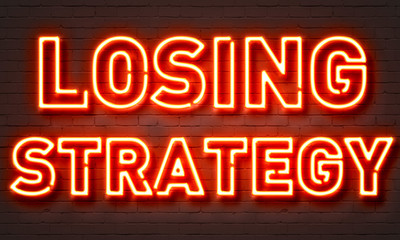 Losing strategy neon sign on brick wall background.