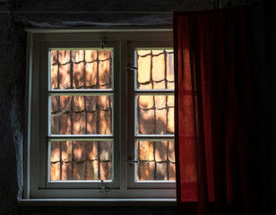 The window with curtain of an old farmhouse inside