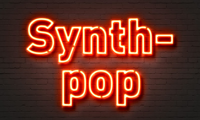 Synthpop neon sign on brick wall background.