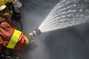 firefighter water spray by high pressure fire hose