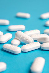 Close up white pills on blue sky background.