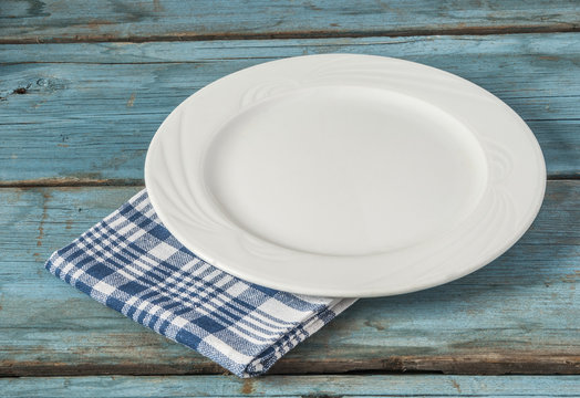 Empty Plate With Napkin On Blue Wooden Table