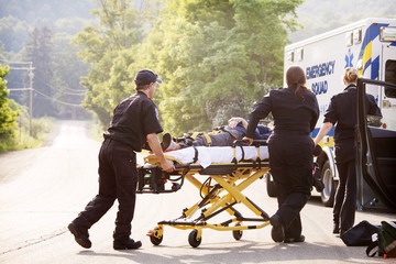 Paramedics taking injured woman to ambulance