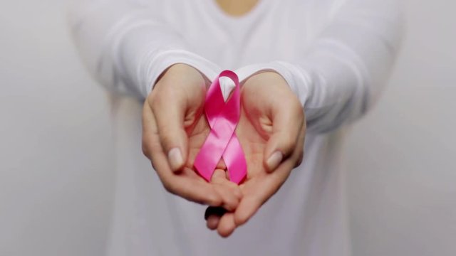 woman holding pink cancer awareness ribbon