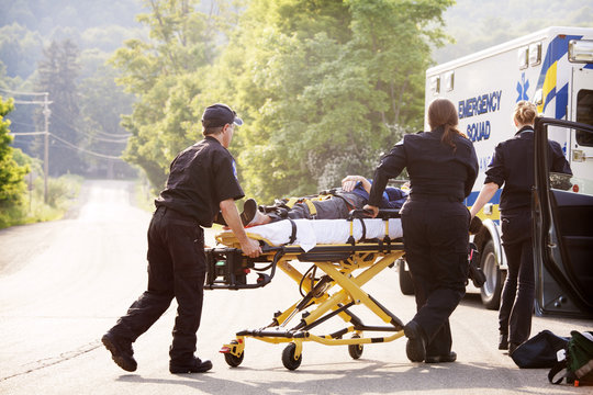 Paramedics taking injured woman to ambulance