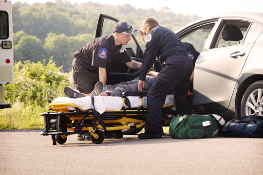 Paramedics getting wounded person out of car